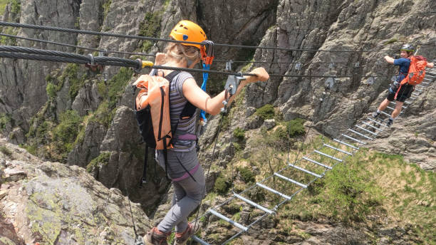 istock Climbers cross ladder on via ferrata 2154615528