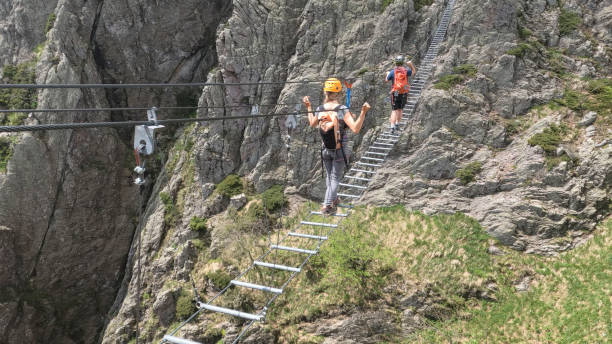 istock Climbers cross ladder on via ferrata 2154615534