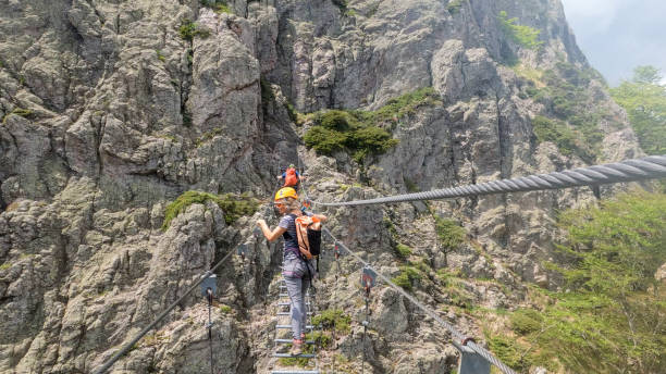 istock Climbers cross ladder on via ferrata 2154615547