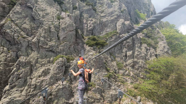 istock Climbers cross ladder on via ferrata 2154615550