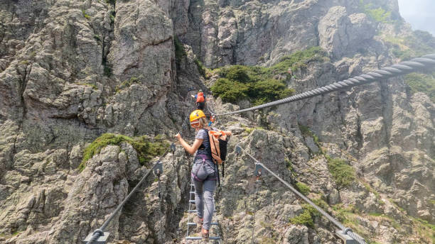 istock Climbers cross ladder on via ferrata 2154615558