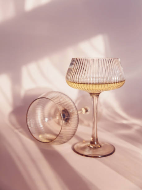 istock Two glasses with white wine placed on light beige background with shadows 2154616760