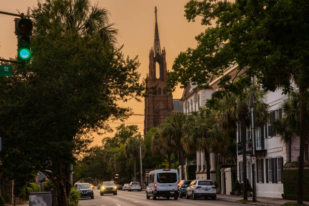 Charleston, South Carolina - May 8, 2024:  A beautiful golden hour scene before sunset of Charleston with the tall steeple of Cathedral of Saint John the Baptist in the center.  HDR encoded.