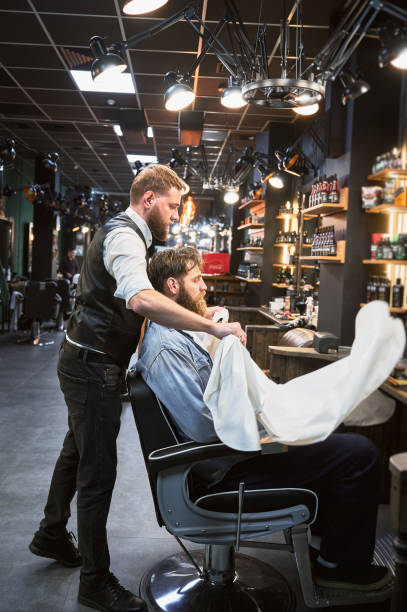 istock Fancy hairdresser putting on a cape on customer. 2154621731
