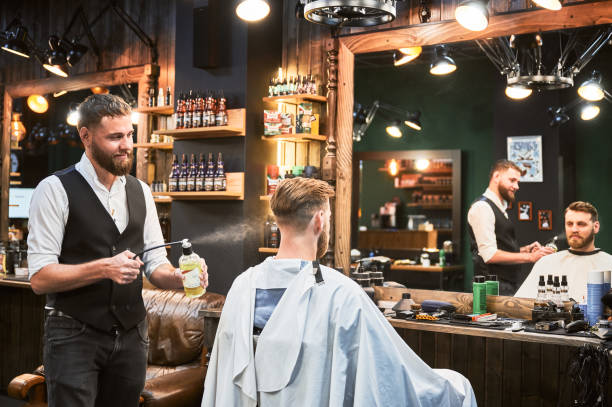 istock Professional barber spraying aftershave lotion on client's nape. 2154621823