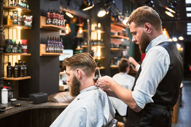 istock Professional barber using comb and electric shaver to cut side hair. 2154621859