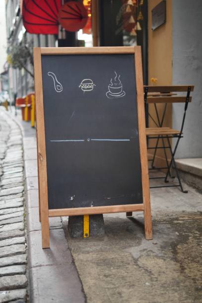 istock Empty wooden blackboard mockup standing outdoors in front of cafe 2154624103
