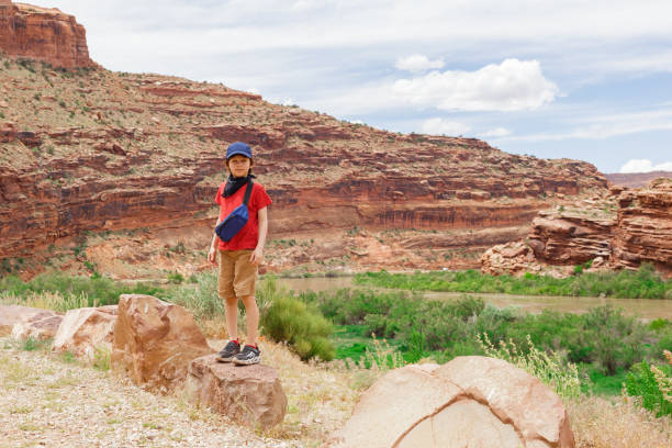 Young Hiker Boy Standing among Rock Formations in Utah, United States