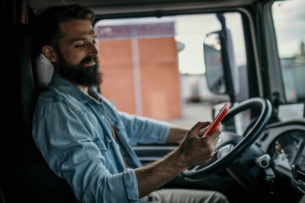 istock Professional truck driver on the road, using a phone 2154626486