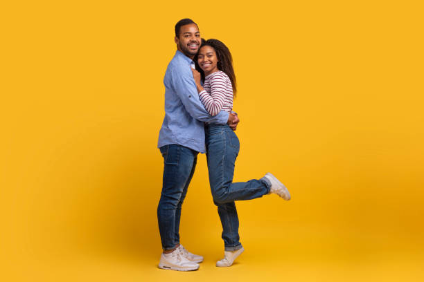 istock Man and Woman Embracing on Yellow Background 2154637874