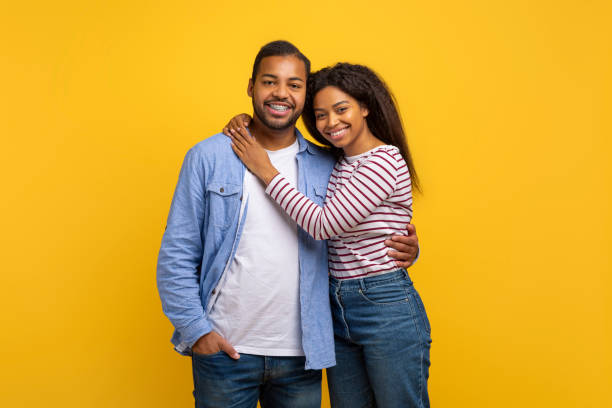 istock Couple Standing Together in Front of Yellow Background 2154637886
