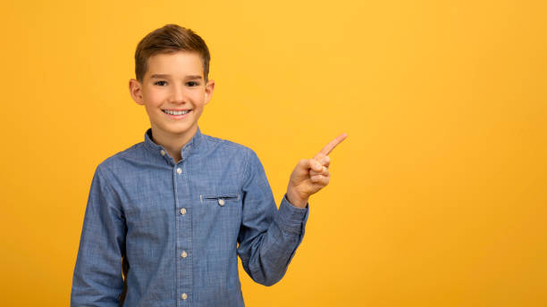 istock Check This. Happy Male Kid Pointing Aside At Copy Space With Finger 2154643365