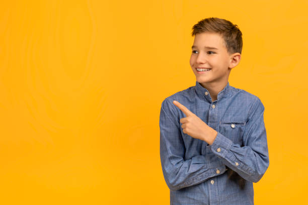istock Check This. Smiling Teen Boy Pointing Aside At Copy Space 2154643372