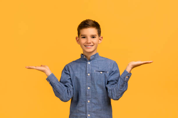 Make Choice. Cheerful teen boy making scales with his empty palms