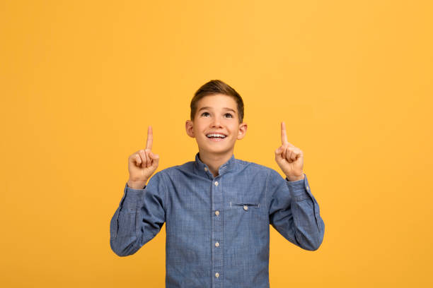 istock Interesting Offer. Excited Teen Boy Pointing Up At Copy Space Above Head 2154643434