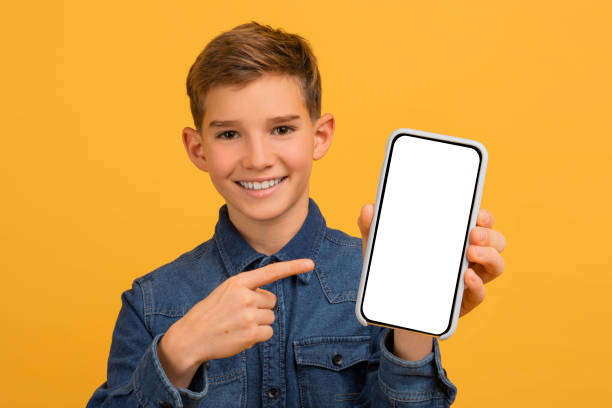 Smiling Handsome Teen Boy Pointing At Empty Smartphone Screen In His Hand