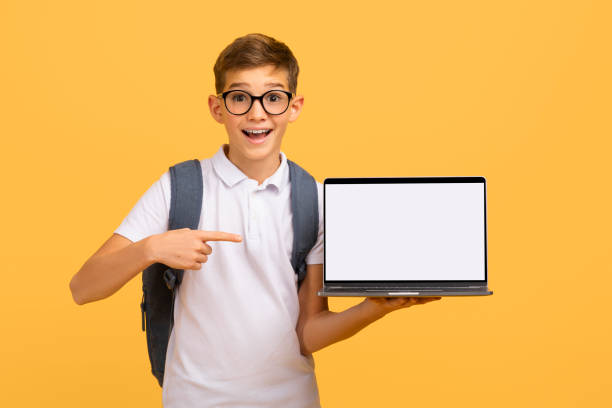 istock Enthusiastic schoolboy wearing glasses pointing at blank white laptop screen 2154643482