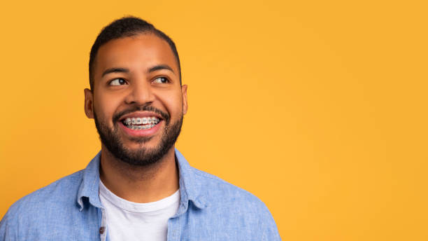 istock Smiling young african american man with orthodontic braces looking at copy space 2154645061