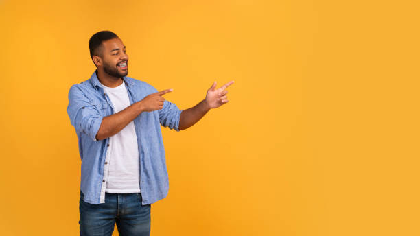 istock Energetic young black man pointing at copy space with two hands 2154645065
