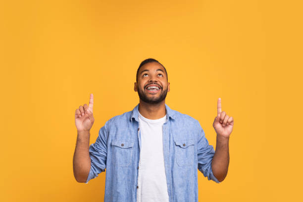 istock Happy young black man pointing up at copy space with two hands 2154645072
