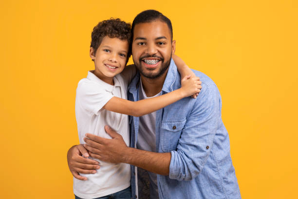 istock Affectionate black father and little son embracing with joyful smiles 2154645092