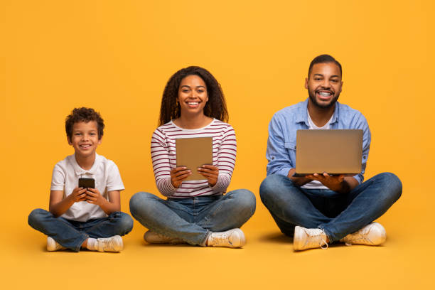 istock Modern black family with preteen son using different tech devices 2154645106