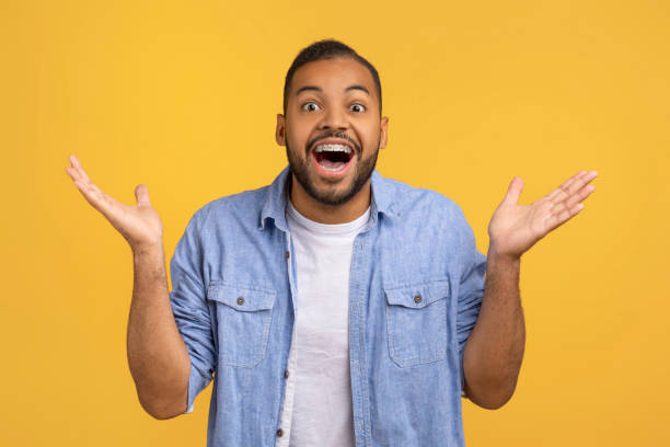 istock Surprised black man looking at camera, opening mouth and raising his hands 2154645130