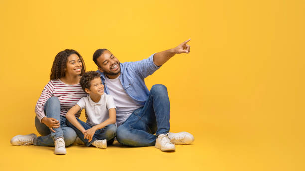 istock Check This. Happy black family sitting together and pointing at copy space 2154645160