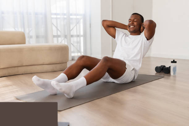 istock Man doing sit-ups at home on yoga mat 2154649952