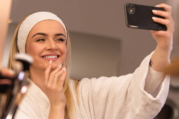 istock Young Beautiful Woman in bathrobe using phone 2154650895