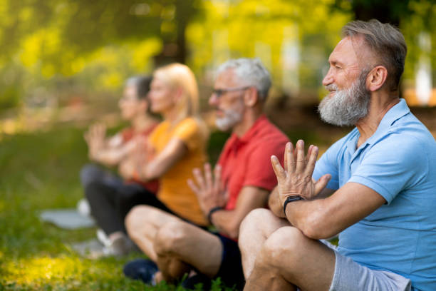 istock Group of focused seniors practicing yoga in serene park setting 2154653384