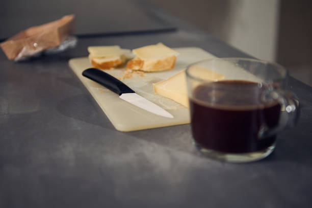istock Still life with a breakfast on the kitchen table. Selective focus on a kitchen knife on the cutting board with sandwiches for lunch 2154658139