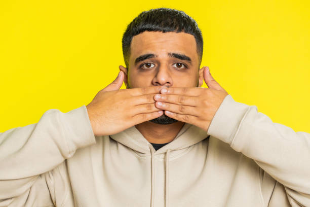 istock Frightened Indian man closing mouth with hands refusing to tell terrible secret, unbelievable truth 2154664164