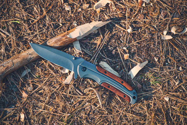 istock Folding hunting knife for survival and sharpened peg lie ground. 2154673182