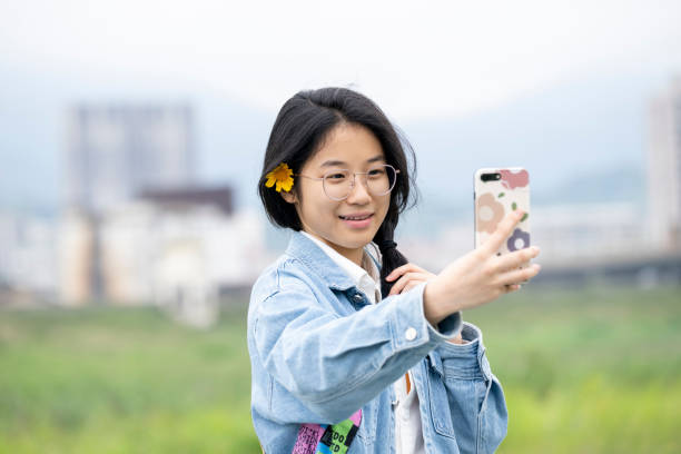 istock Girl taking selfie with mobile phone in park 2154675323