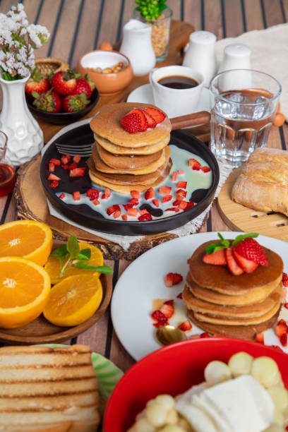 istock Breakfast table full of food brunch pancakes, bread and fruit 2154678125
