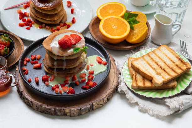 istock Breakfast table full of food brunch pancakes, bread and fruit 2154678253