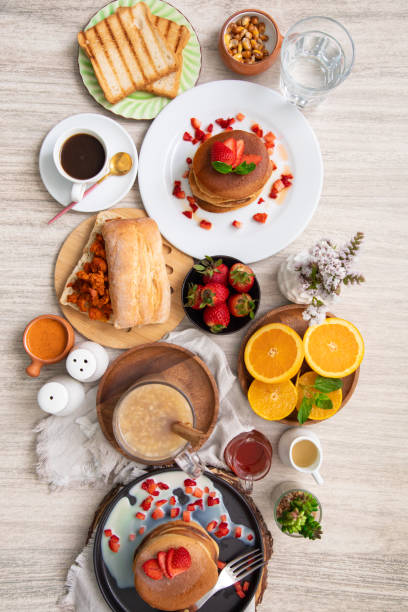 istock Breakfast table full of food brunch pancakes, bread and fruit 2154680176