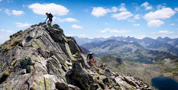 Holidays in Poland - Swinica peak in the Tatra Mountains Several tourists on Swinica, one of the highest peaks in the Polish Tatra Mountains high tatras stock pictures, royalty-free photos & images