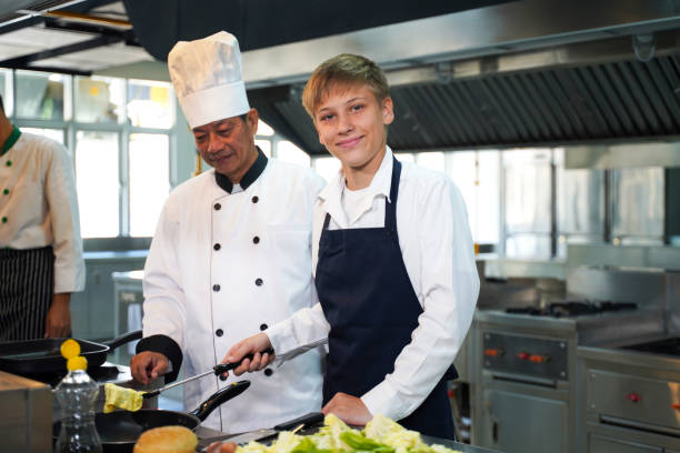 istock Chef teacher teaches cooking to the group children in class kitchen room.  Chef preparing student for learning marking and cooking food at workshop.  Education Concept 2154691791