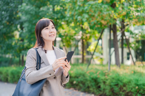 istock Businesswoman walking while using her phone 2154692336