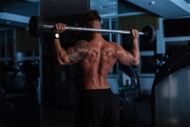 istock Athletic strong bodybuilder man with bare back and muscles doing exercise in the gym at night 2154696338