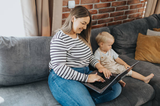 istock Mother taking care of her child while working from home 2154697848