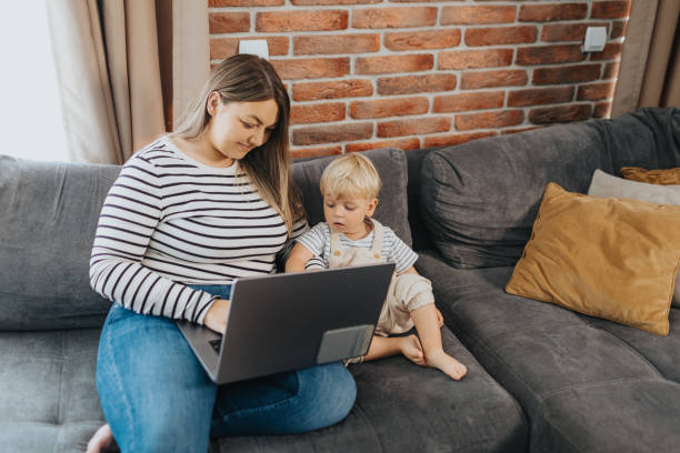 istock Mother taking care of her child while working from home 2154698067