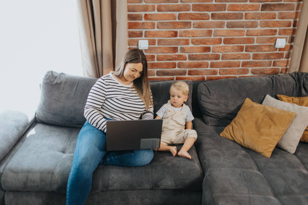istock Mother taking care of her child while working from home 2154698668