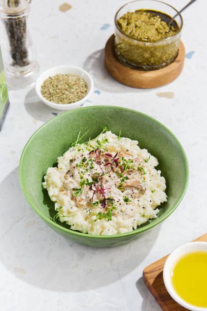 istock Mushroom Risotto with Fresh Herbs in a Green Bowl on Marble Table Enhanced with Condiments and Light Highlights 2154700257
