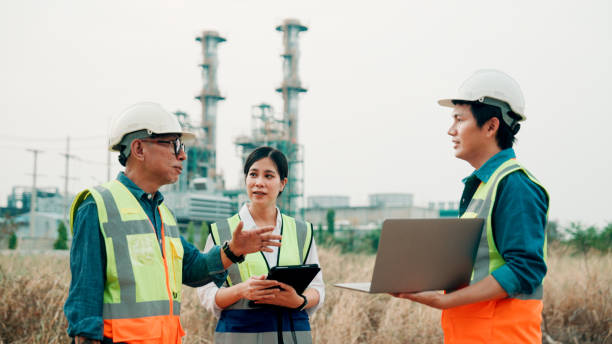istock Business people, architect and tablet in construction planning, meeting or collaboration on site. Group of engineer, builder or contractors on technology for team project or industrial architecture. 2154701235