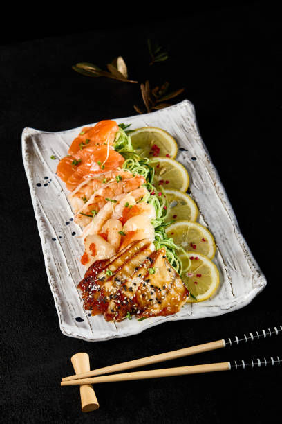 Multi-Ethnic Friends Enjoying Sashimi Platter with Salmon, Shrimp, Scallop, Eel at Evening Gathering