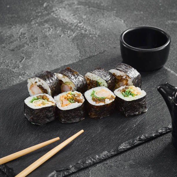 istock Mixed Filling Sushi Rolls with Seaweed Wrap on Dark Stone Surface 2154701863