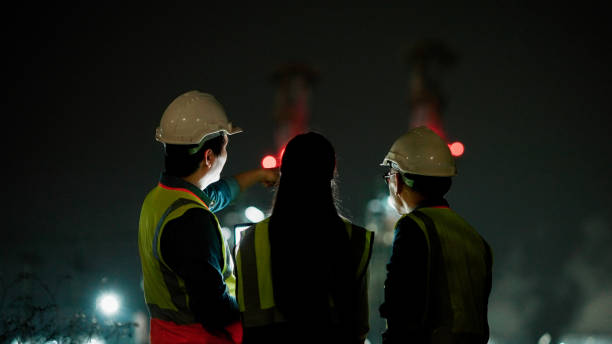 Business people, architect and tablet in construction planning, meeting or collaboration on site at night.